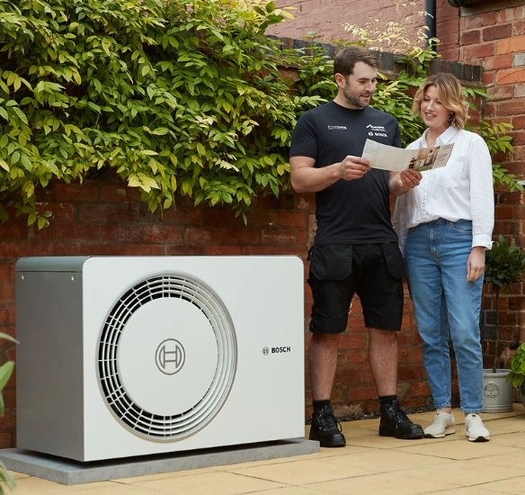installer and consumer in front of heat pump